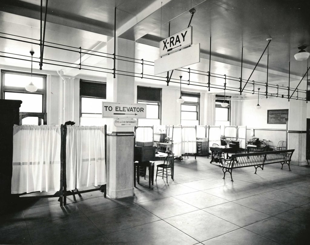 high-ceilnged windowed outpatient waiting room with privacy screens and bench seating