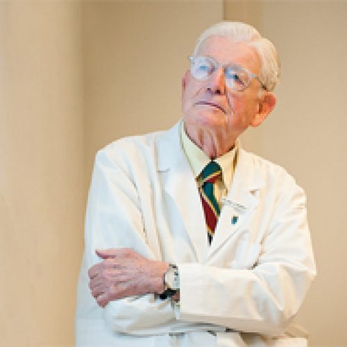 Paul Russell MD older physician with glasses and white coat