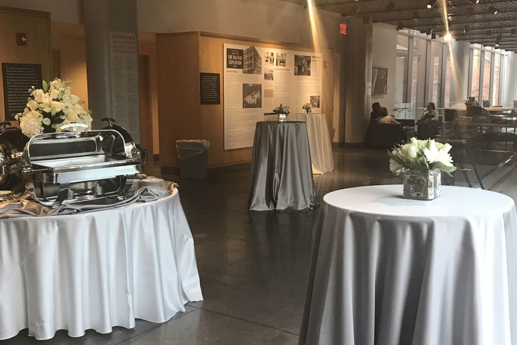 Round tables covered with silver linen and flowers