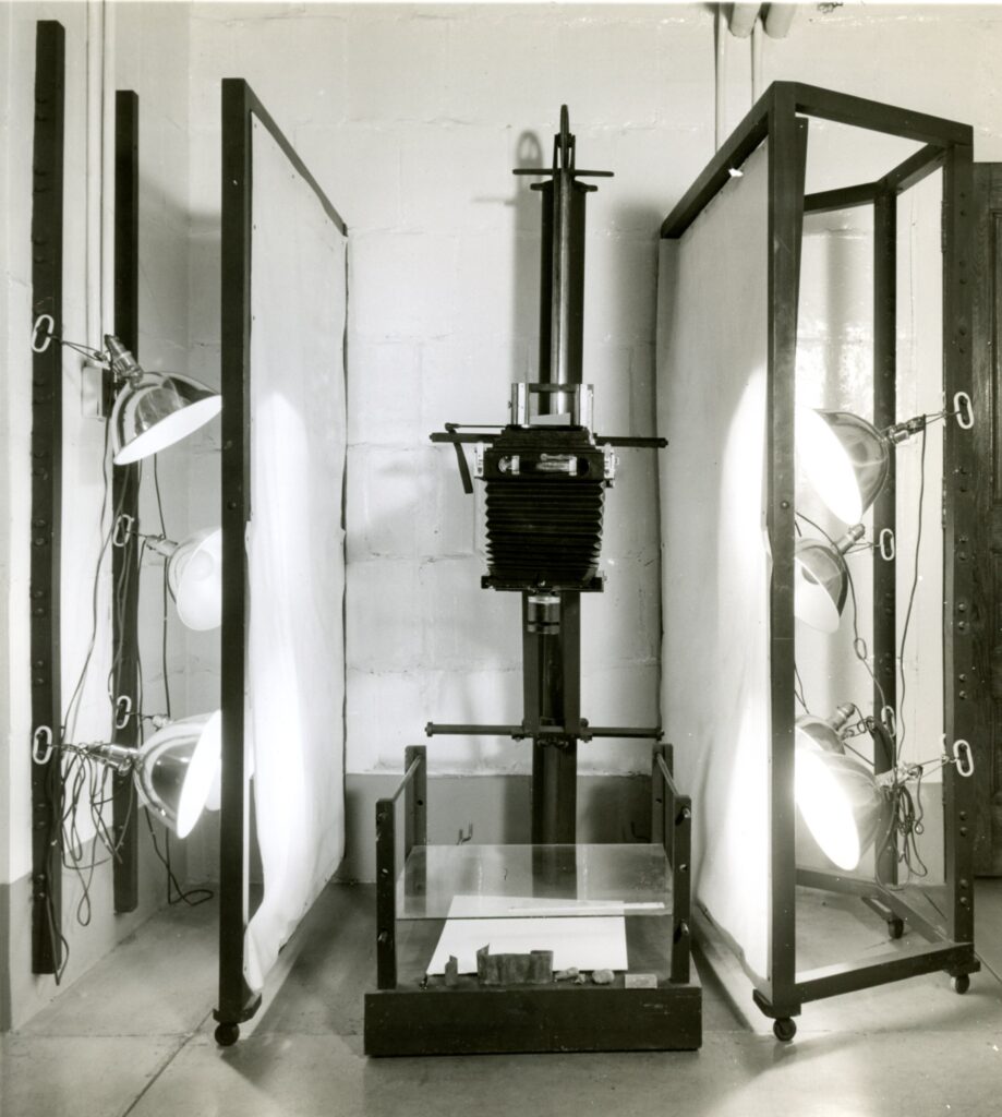 A large overhead camera photographs a surgical specimen inside of a lightbox