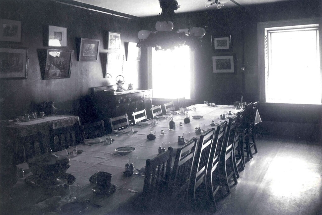 black & white photo of a long table with several chairs