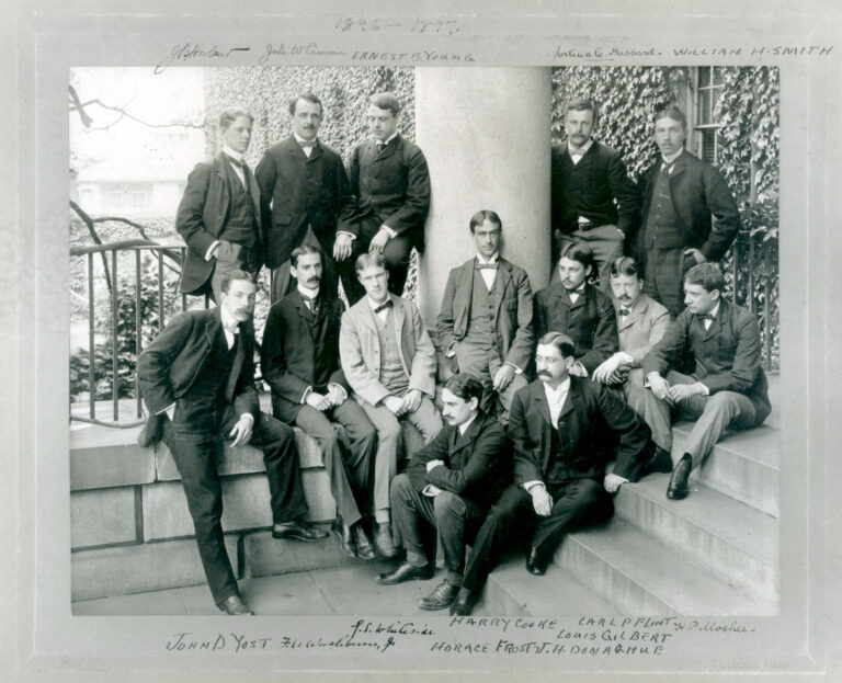 black & white group photo of fourteen men, each identified by writing in the margins of the frame