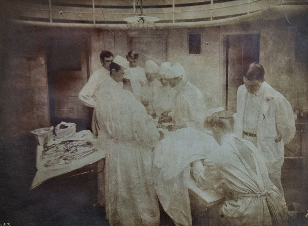 Sepia-toned photo of 9 people performing an operation