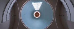 Point of view is looking straight up at the dome from the floor. Pale blue dome is interrupted by a gridded window, notched out of roughly 1/10th of the diameter