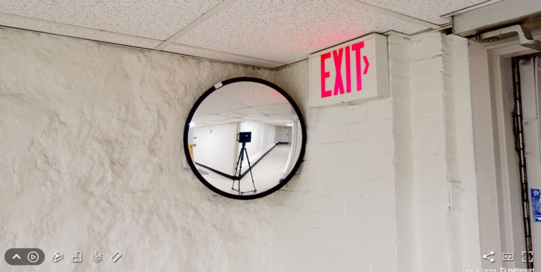 A screenshot of a camera reflected in a hallway security mirror